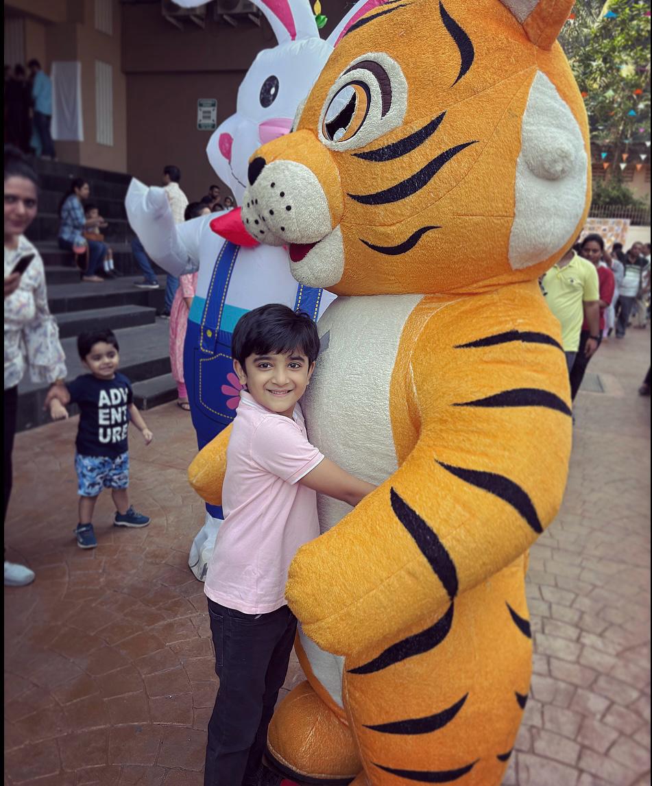 Child enjoying the Tiger Buddy mascot at a Toywala event